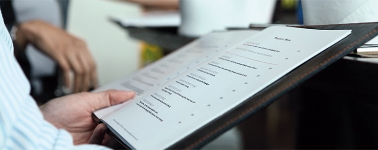 Pessoa a consultar menu de um estabelecimento de restauração