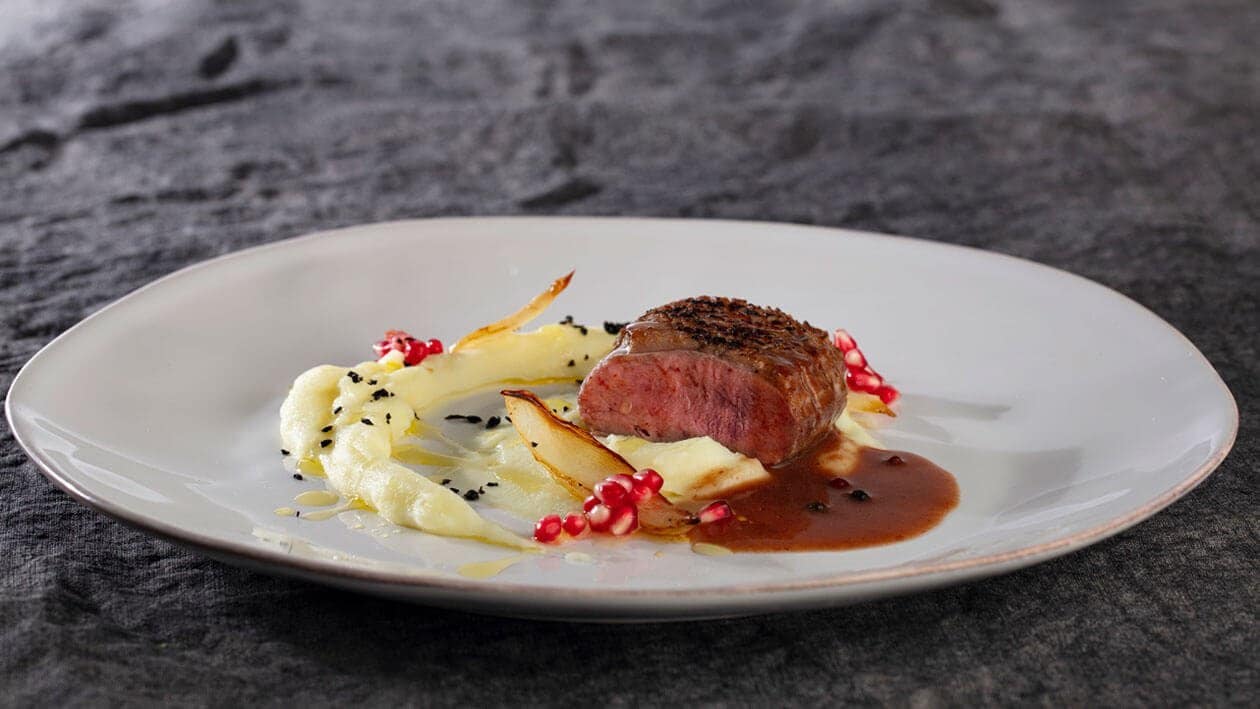 Magret de pato com puré, cebola caramelizada e molho de frutos silvestres